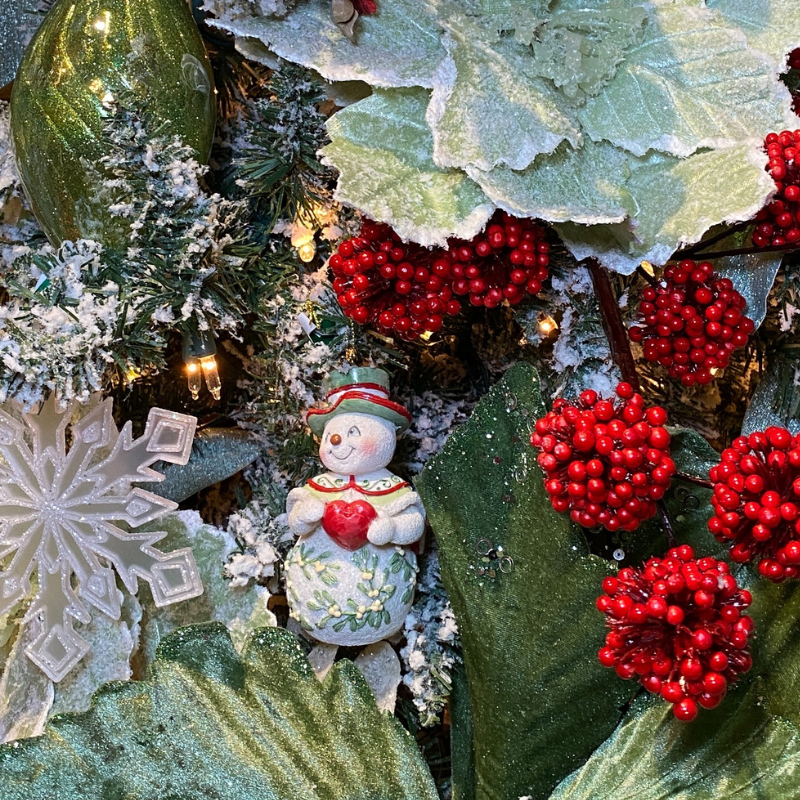 Decorative Christmas  snowman figurine ornament, red berries, and greenery  in the moments of thyme room in christmas land 2025 at dewayne's