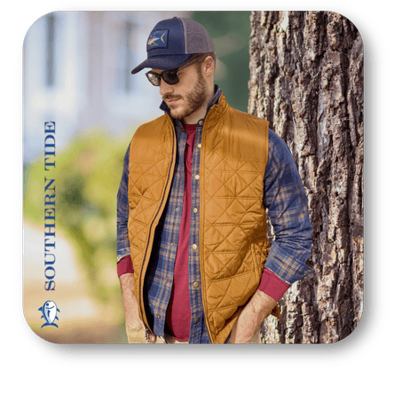 Man wearing a mustard yellow quilted vest, plaid shirt, and cap with 'Southern Tide' branding in the men's shoppe at Dewayne's in Selma, NC minutes from Raleigh, Cary, Clayton, Garner, Smithfield, Goldsboro