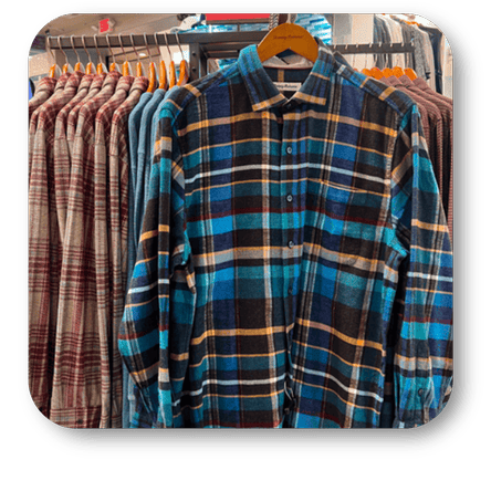 Plaid shirt hanging on a rack with other shirts in the men's shoppe at Dewayne's in Selma, NC minutes from Raleigh, Cary, Clayton, Garner, Smithfield, Goldsboro