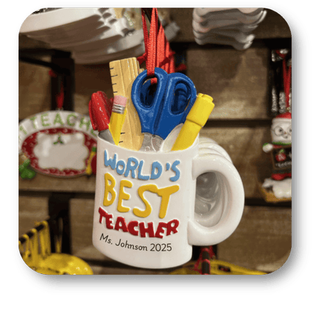 Mug with 'World's Best Teacher' text and personalized name and year, surrounded by classroom supplies at Dewayne's in Selma, NC minutes from Raleigh, Cary, Clayton, Garner, Smithfield, Goldsboro