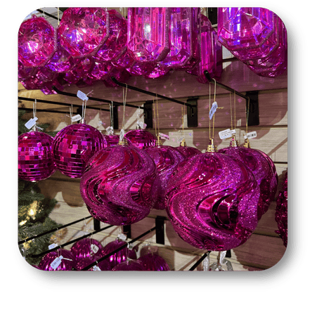Pink glass ornaments hanging on a stand with a blurred background  in the wrapped in red room in christmas land at Dewayne's in Selma, NC minutes from Raleigh, Cary, Clayton, Garner, Smithfield, Goldsboro