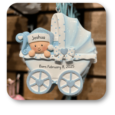 Personalized baby ornament with a baby in a blue stroller, name 'Joshua', and birth date 'Born February 8, 2025' in the personalization room at Dewayne's in Selma, NC minutes from Raleigh, Cary, Clayton, Garner, Smithfield, Goldsboro

