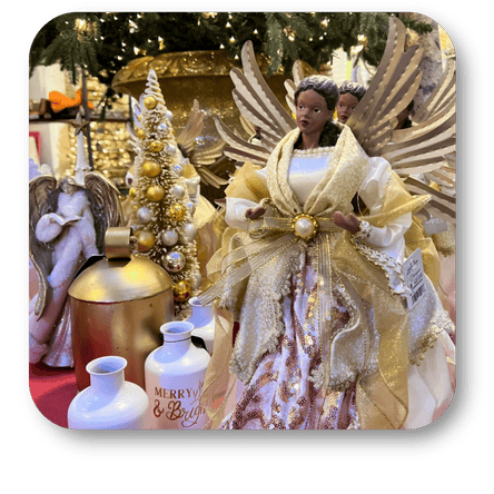 Decorative angel figure with gold wings and attire, surrounded by Christmas decor in the gold and glamour room in christmas land at Dewayne's in Selma, NC minutes from Raleigh, Cary, Clayton, Garner, Smithfield, Goldsboro