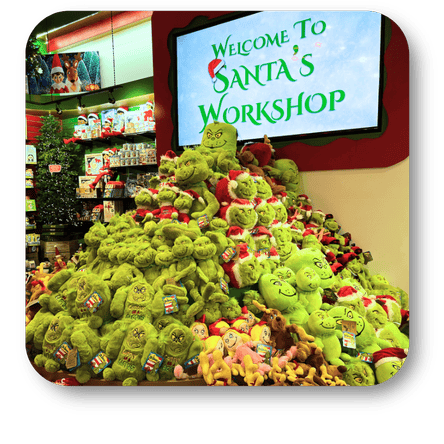 Display of green plush grinch toys with a 'Welcome to Santa's Workshop' sign in the background  at Dewayne's in Selma, NC minutes from Raleigh, Cary, Clayton, Garner, Smithfield, Goldsboro