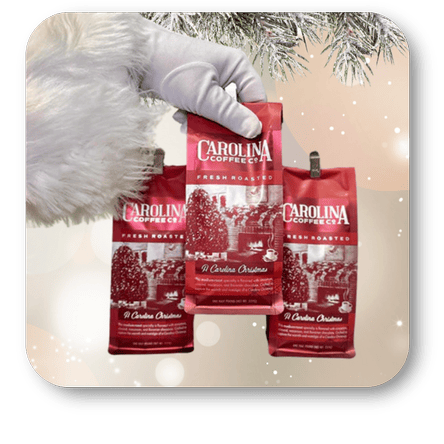 Santa's hand holding Carolina Coffee bags with a Christmas tree in the background in the sweet shop at Dewayne's in Selma, NC minutes from Raleigh, Cary, Clayton, Garner, Smithfield, Goldsboro