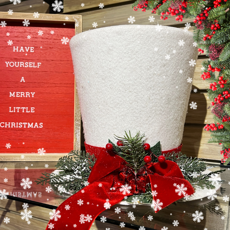 Decorative christmas white hat with red ribbon and greenery found in the wrapped in red room in christmas land 2025 at dewayne's