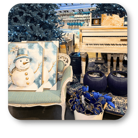 Decorative Christmas setting with a snowman painting, blue flowers, and a piano in Christmas Land at Dewayne's in Selma, NC minutes from Raleigh, Cary, Clayton, Garner, Smithfield, Goldsboro